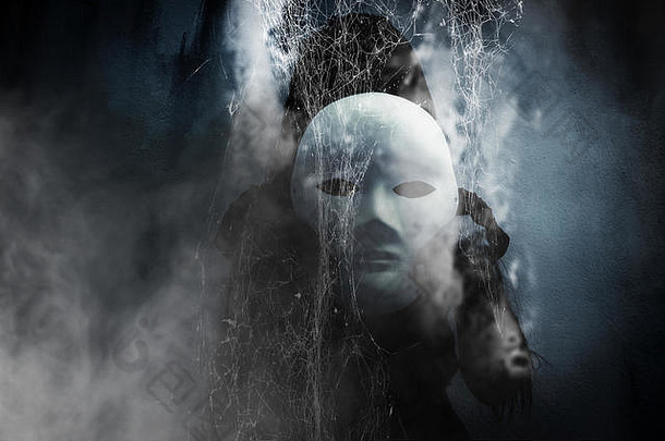 神秘的黑衣女人戴着白色面具藏在蜘蛛网后面，<strong>书的封面</strong>背景很恐怖