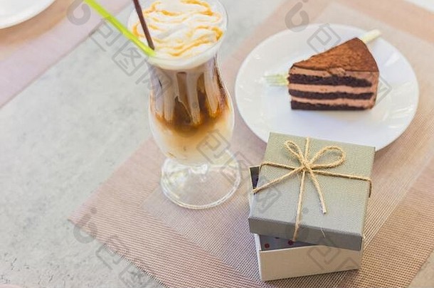 打<strong>开盘</strong>子上的蛋糕和奶茶旁边的空礼品盒。它们在桌子上。度假礼物。