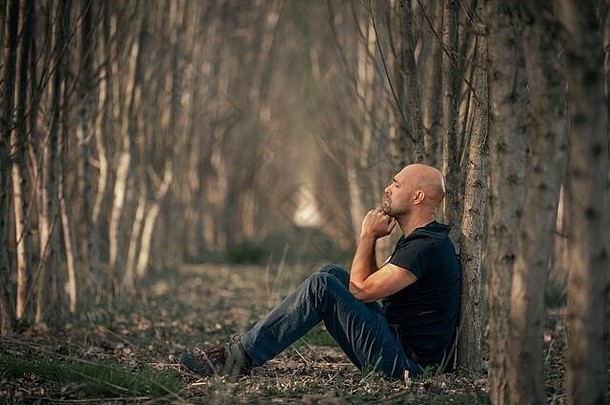 患有抑郁症的坐着的男人在他的生活中经历了一段艰难的时期，遭受着精神疲惫、焦虑、倦怠的折磨