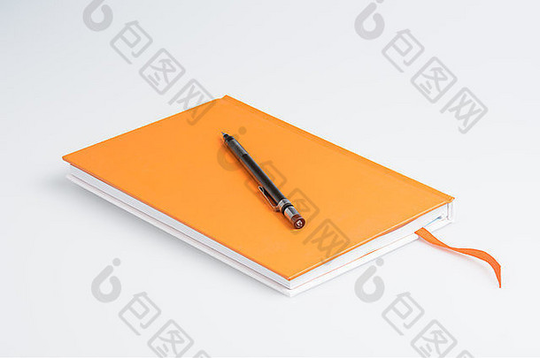 带白色背景笔的橙色笔记本