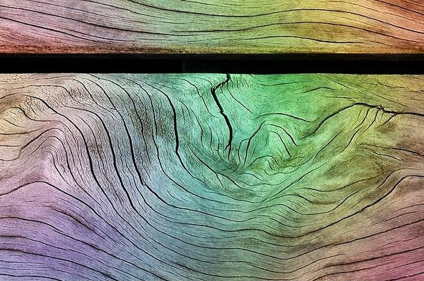 具有彩虹效果背景的木纹纹理木板，多色蜡笔，硬质木质材料表面的明亮渐变。很酷的图案，明亮