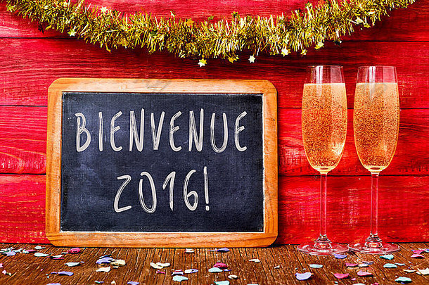 黑板上用法语写着“bienvenue 2016，welcome 2016”，一些五彩纸屑和一副带香槟的长笛玻璃杯