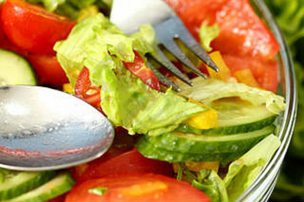 盘子里的银叉混合沙拉和新鲜蔬菜