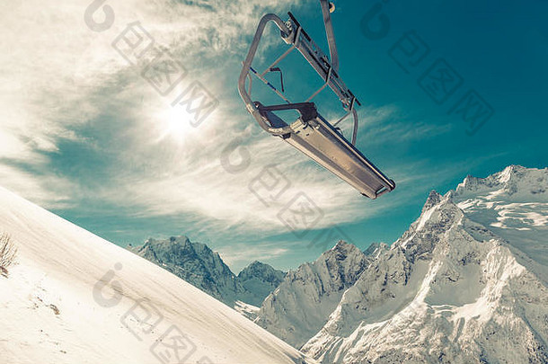 椅子电梯山腰背景蓝色的天空白雪覆盖的山明亮的冬天太阳健美的图像