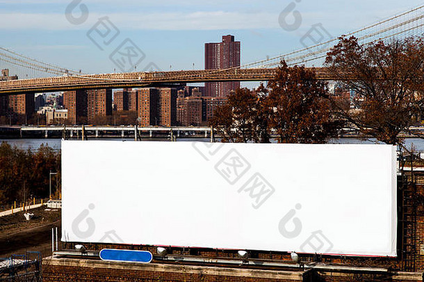 一块巨大的白色空白广告牌，位于布鲁克林东河岸边，有布鲁克林大桥和曼哈顿东南部