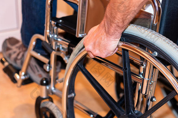 残疾人手推轮椅轮的特写镜头。残疾概念