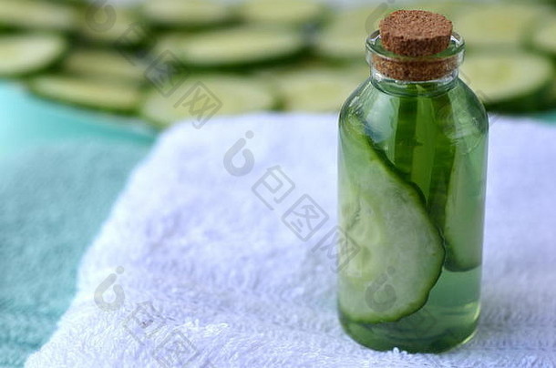 新鲜黄瓜片和天然美容面部爽肤水装在一个有复印空间的玻璃瓶中。SPA和美容概念。