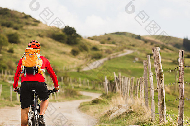 骑山地车的人在夏季的山地景观中骑自行车。在乡村公路上骑自行车的男子。运动健身动机与<strong>健康教育</strong>
