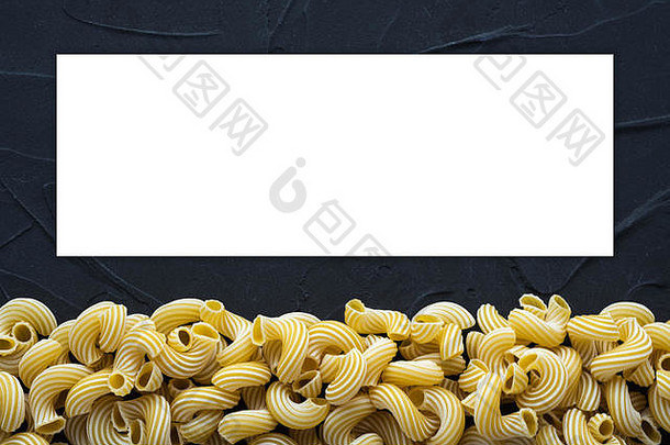意大利里加通心粉——美丽的面食，底部有黑色纹理背景。从顶部的特写视图。文本和想法的空白。