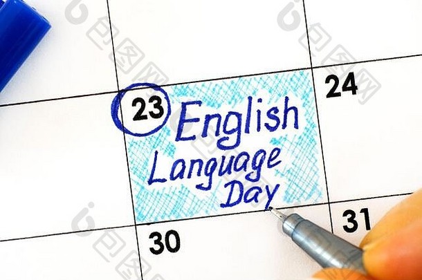女人用手指在日历上用钢笔书写提醒英语日。四月二<strong>十三号</strong>。