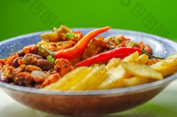 墨西哥菜：鸡胸肉片配辣椒和奶酪番茄酱，配脆土豆片和蓝盘子上的薄荷豆沙拉