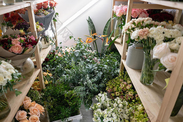 花店概念。不同品种的鲜春花在冷藏室里换花。架子上的花束，花店生意。