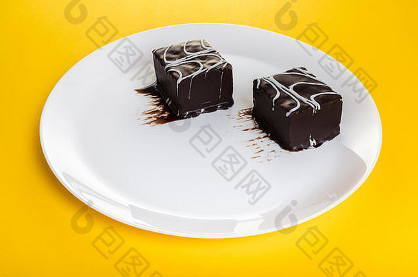黄色背景盘中的巧克力甜点蛋糕