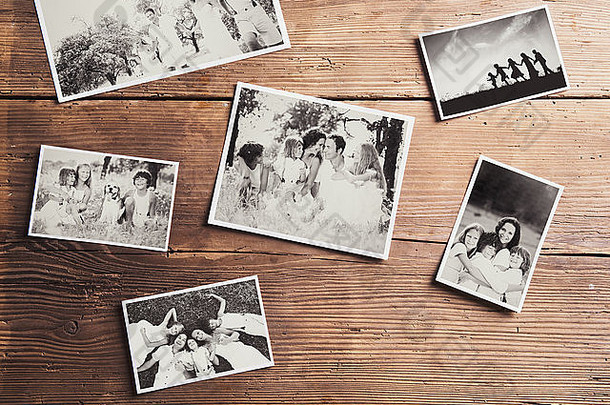 放在桌子上的黑白家庭照片。工作室在木制背景上拍摄。