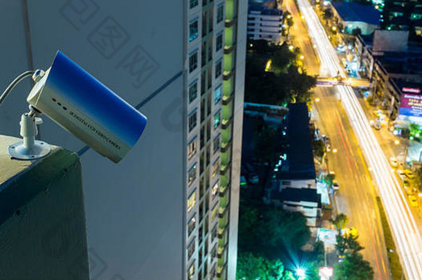 闭路电视摄像机或监控系统在夜间运行，背景为城市模糊