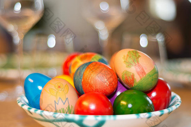 复活节彩蛋由孩子们自己画在一张桌子上，桌上摆着酒杯，桌上有一件来自奥地利的精美的Gmundner Keramik瓷器。