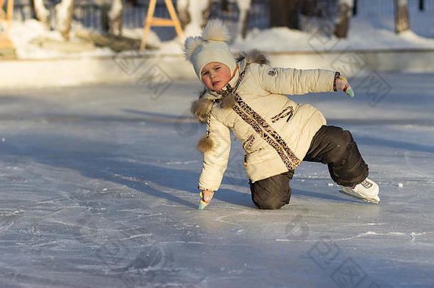 一个孩子在寒冷的日子里穿着暖和的夹克，戴着帽子滑冰。