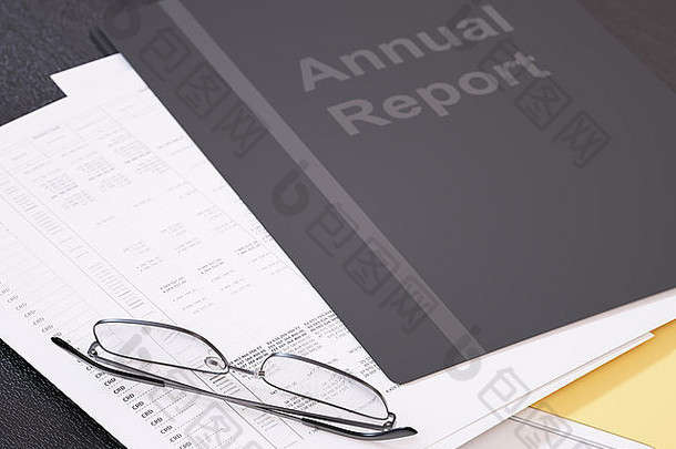 商业财务报告和桌子上的眼镜特写