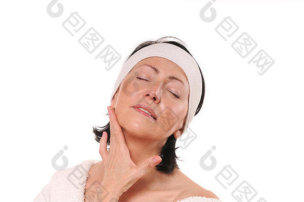 成熟的女人温柔地抚摸她的脖子。老妇人把油揉进皮肤。老皮肤护理。白色的隔离带。摄影棚拍摄