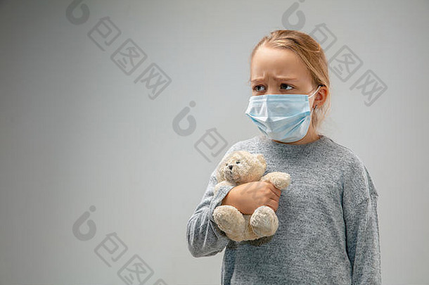 不能呼吸。高加索小女孩戴着呼吸防护面罩，以防空气污染和灰尘颗粒超过安全限值。医疗、环境、生态概念。和泰迪熊。