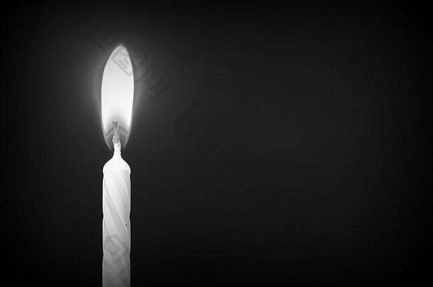 黑暗背景特写下的生日蜡烛。非黑即白的