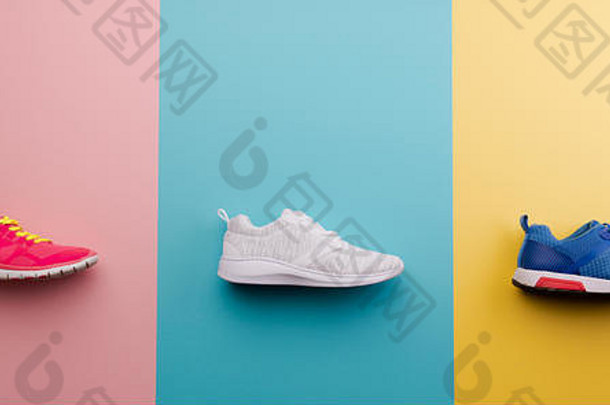 在明亮的颜色背景上拍摄跑步鞋的摄影棚照片。平铺。