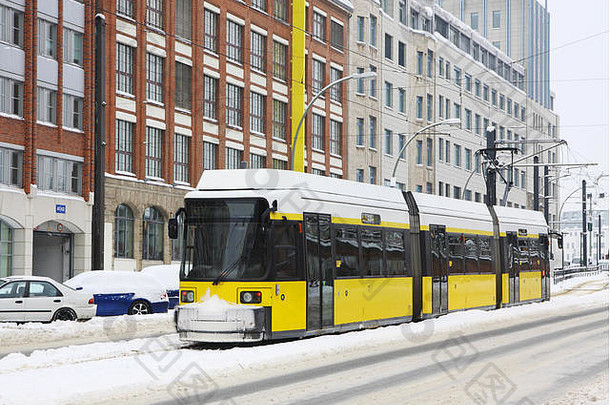 德国柏林雪地街道上的黄色有轨电车