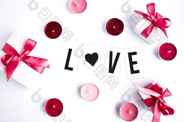白色桌面背景上的爱情文字，带有礼品盒和蜡烛