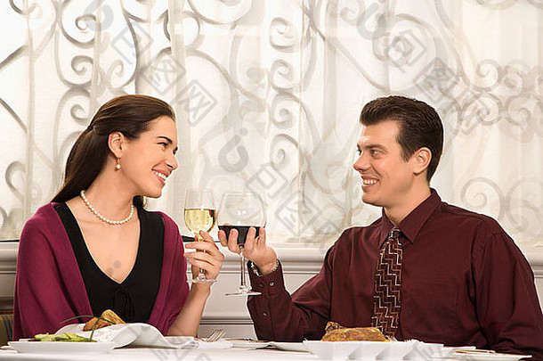 一对中年白人夫妇在餐厅里微笑着敬酒