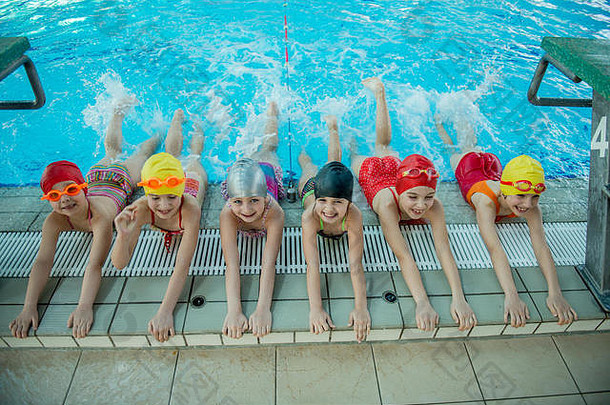 教练和一群孩子在游泳池附近做练习