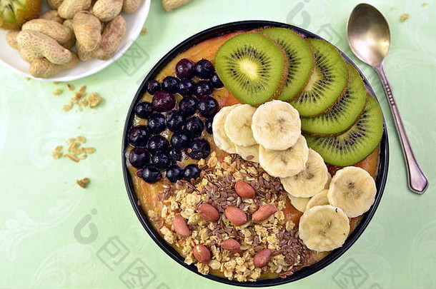 早餐有<strong>慕斯</strong>丽、acai蓝莓冰沙、猕猴桃、香蕉、绿色背景的水果。健康食品概念。
