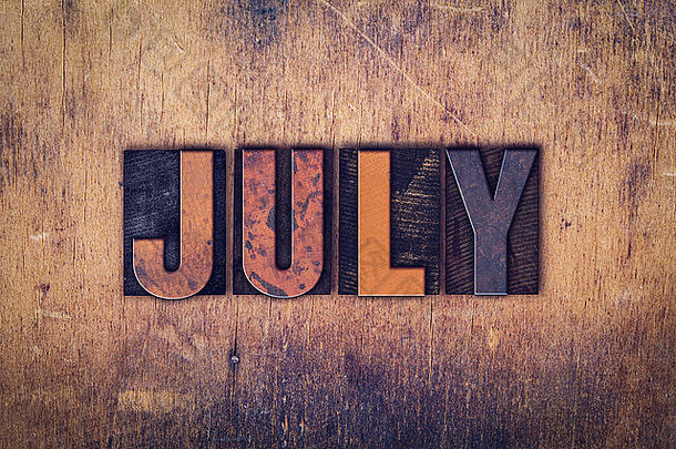 “七月”这个词是在一个陈旧的木制背景上用肮脏的老式活版印刷字体写的。
