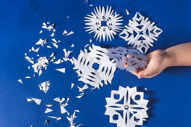 各种圣诞主题雪花的背景，在流行的蓝色背景上用白纸剪下
