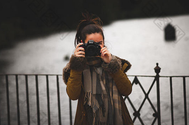 年轻的女摄影师采取照片相机