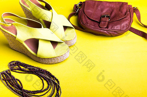夏季女装配饰套装。棕色包黄色平台凉鞋，项链。平铺