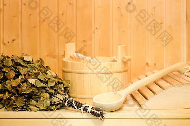 芬兰古典桑拿或俄罗斯浴中的木桶、桦木扫帚和其他配件。木质背景上的自由空间