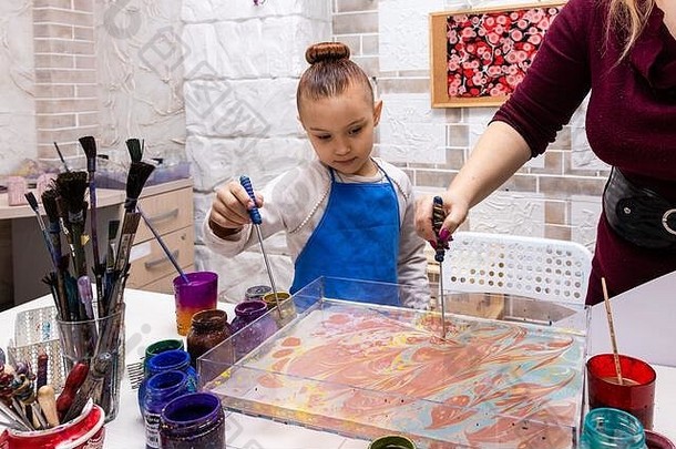 Ebru工作室的大师班-水上绘画艺术。女老师和6岁的女孩一起合影