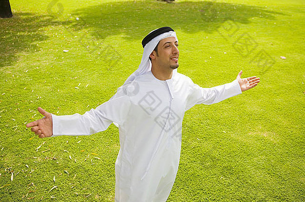 站在公园里的阿拉伯男子伸出双臂