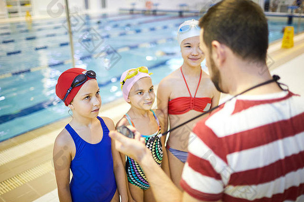 一群女孩在听游泳教练