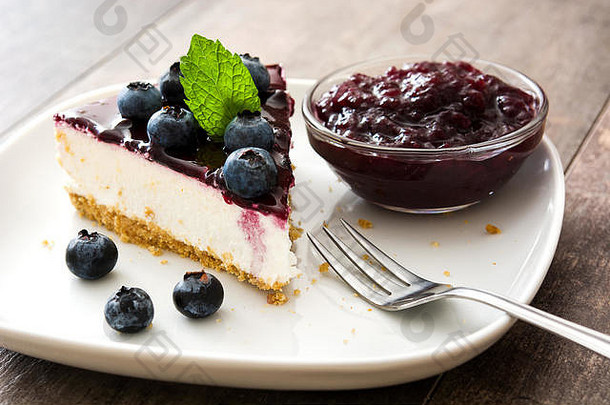 木桌上的一块蓝莓芝士蛋糕