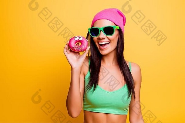 美丽的兴奋赶时髦的人女孩粉红色的他持有粉红色的甜甜圈黄色的墙