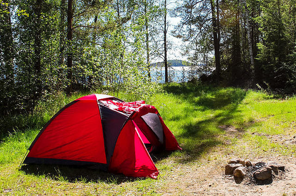 <strong>夏季</strong>在芬兰（斯堪的纳维亚）湖边的森林里<strong>露营</strong>，有红色帐篷和壁炉（芬兰，欧洲）