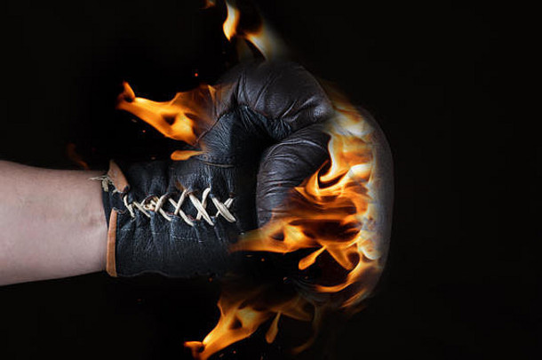 黑色背景上火焰中的棕色皮革手套，特写