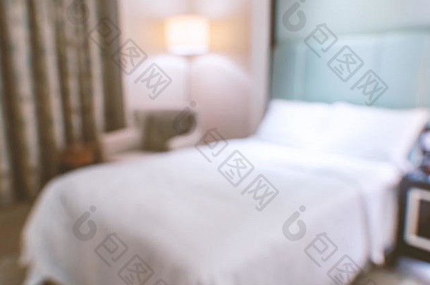 干净舒适的现代酒店卧室内设双人床，抽象的散焦模糊背景，豪华旅行的设计理念。