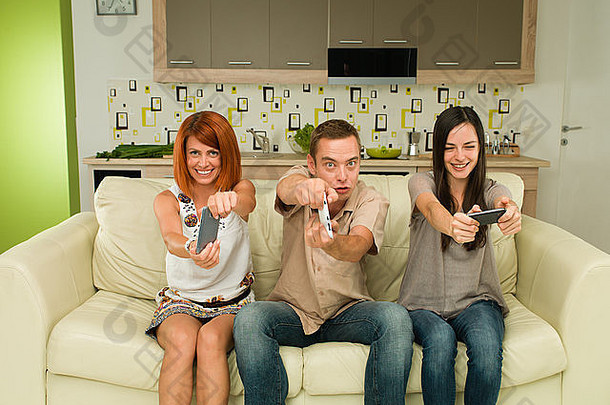 年轻的快乐高加索人人坐着沙发上有趣的玩视频游戏