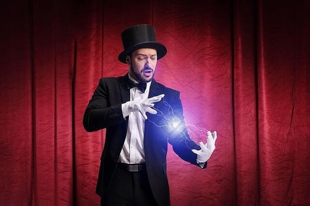 魔术师在红幕舞台上表演魔术并发电