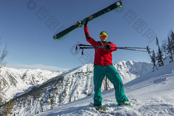 肖像：年轻人在山上拿着滑<strong>雪镜</strong>。