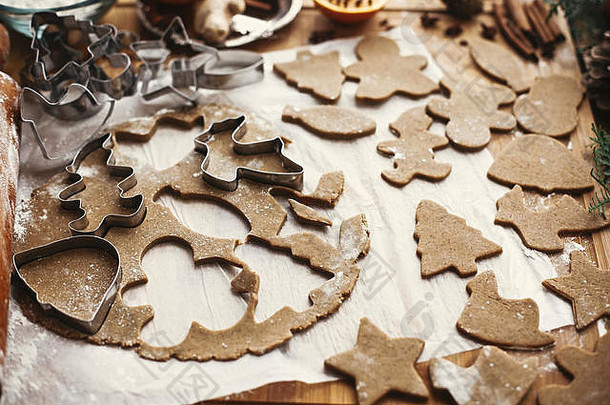 姜饼面团，带有不同形状的金属切割器，用于制作圣诞饼干和木制擀面杖、茴香、生姜、肉桂、松果、冷杉枝