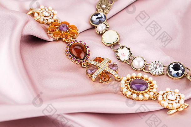 以珍珠和宝石为面料背景的时尚手镯。