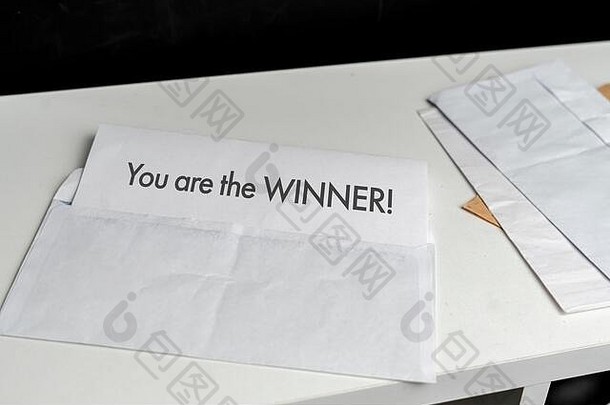 一个打开的信封，里面有一张纸，上面写着“你是<strong>中奖</strong>者，祝贺你，彩票成功”